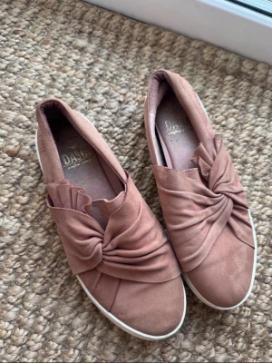 Rosa loafers med knut från Duffy - Säljer ett par  rosa loafers från Duffy med dekorativ knut framtill. Skorna har en mjuk ovandel i mockaimitation och vit sula. 