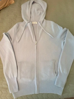 Ljusblå zip up hoodie från Soft Goat - Mysig ljusblå hoodie från Soft Goat i mjuk och lyxig kashmir. Dragkedja framtill, två fickor och ribbade muddar vid ärmar och nederkant🩵