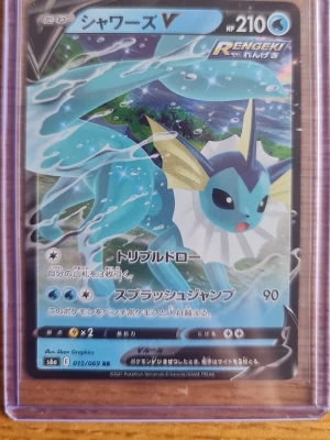 Japansk Pokémonkort Vaporeon V - Säljer ett japanskt Pokémonkort med Vaporeon V (シャワーズV) från Rengeki-serien. Kortet har blå och turkosa färger med Vaporeon i vattenmiljö. HP 210 och flera attacker på japanska. Kortet är inplastat i ett genomskinligt plastfodral.