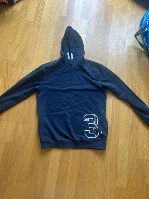 Vinson Polo club hoodie - Säljer en mörkblå hoodie från Vinson Polo Club med stort vitt tryck av siffran 3 och text på framsidan. Perfekt för dig som gillar en skön hoodie