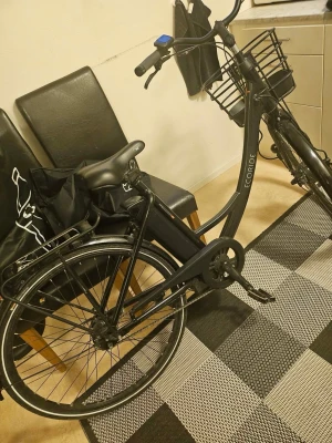 Svart elcykel från Ecoride - Säljer en svart elcykel från Ecoride med klassisk ram, cykelkorg fram och pakethållare bak. Cykeln har batteri monterat på ramen, bekvämt sadel och handtag samt skärmar över hjulen. Perfekt för smidig och miljövänlig transport i stan. Display måste bytas för den är låst råka låsa den. Nytt batteri 