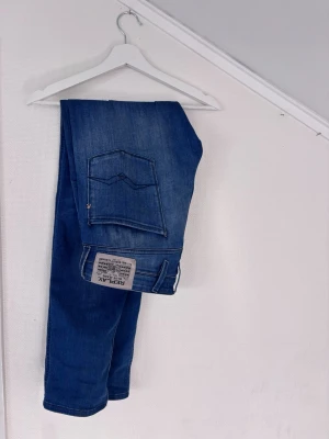 Blå slim fit Replay Anbass - Säljer ett par blå slim fit jeans från Replay, modell Anbass. Jeansen har klassisk femficksdesign, snygga sömmar på bakfickorna och en patch med Replay-logga. Tillverkade i mjukt denimtyg som sitter skönt och har en modern passform. Använts mycket sparsamt. Kan absolut ta fler bilder vid önskemål. Kolla gärna under min profil för liknande plagg. Uppskattar snabba affärer 🙏