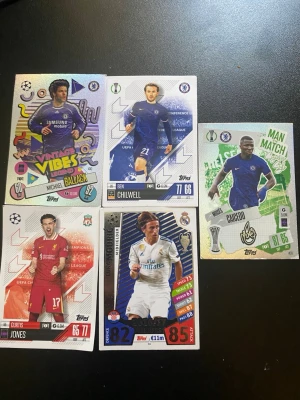 Samling fotbollskort Topps UEFA - Fem olika fotbollskort från Topps UEFA Champions League-serie. Korten har färgstarka designer och visar spelare från Chelsea, Liverpool och Real Madrid. Materialet är glansig kartong och varje kort har unika illustrationer, statistik och klubbmärken.