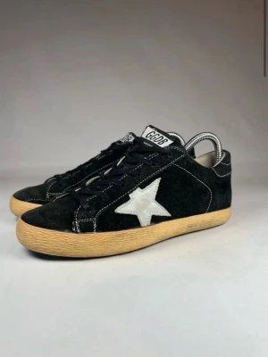 Golden Goose svarta sneakers med stjärna - Säljer ett par tvär feta Golden goose skor i storlek 39, de är svåra att få tag på & väldigt sällsynta. De är i mycket bra skick vilket du kan se på bilderna.  - endast skorna medföljer vid köp! 😊   självklart äkta ✅   nypris~ 6000kr 