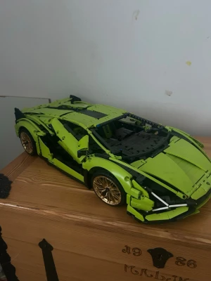 Limegrön LEGO sportbil - Säljer en detaljerad limegrön LEGO sportbil med guldfärgade fälgar och svarta detaljer. Bilen har öppningsbara dörrar och realistisk design inspirerad av en lyxbil. Perfekt för dig som gillar byggsatser och bilar. Du får också med lådan till den.perfekt till dig som gillar och spara på saker eller gillar och bygga på Lego 