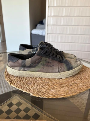 Saint Laurent Camouflage - Sjukt feta sl/06 i sällsynt camo färg, väl använda och slitna på sina ställen men fullt fungerande. Storlek 43, inget og och säljs begagnat för upp mot 4 000. Kom med bud!