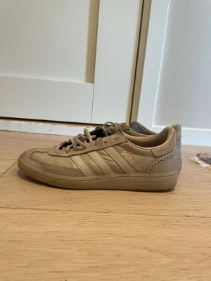 Beige Adidas Spezial sneakers - Säljer ett par beige Adidas Spezial sneakers med klassiska tre ränder på sidan och spetsig tå. Skorna är låga och har en snygg retrodesign med detaljer i mocka och läder. Perfekta för dig som gillar streetstyle och ikoniska modeller.