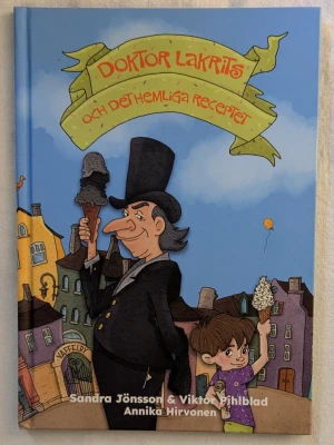 Doktör Lakrits och det hemliga receptet - En färgglad barnbok med hårda pärmar, illustrerad framsida med en man i hög hatt och ett barn som äter glass. Boken är skriven av Sandra Jönsson och Viktor Pihlblad, illustrationer av Annika Hirvonen. Perfekt för dig som gillar äventyr och mysterier.