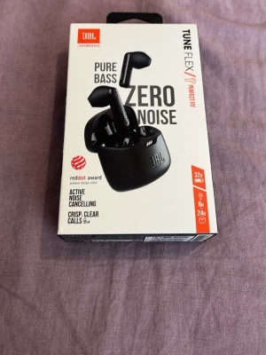 JBL Tune Flex True Wireless Hörlurar - JBL Tune Flex är svarta true wireless-hörlurar med aktiv brusreducering, Pure Bass-ljud och mikrofon för tydliga samtal. De har Bluetooth 5.2, upp till 32 timmars batteritid och laddas via USB-C. Snygg och modern design med laddningsetui.