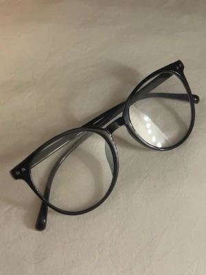 Svarta runda glasögon - Snygga svarta glasögon med rund form och klassisk design. Perfekta för dig som vill ha en tidlös accessoar med ungdomlig vibe.