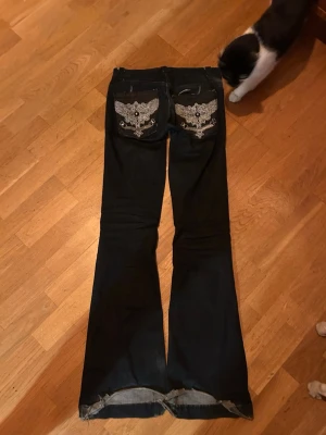 Svarta utsvängda jeans - Säljer de för att de inte är min stil längre, ganska använda men priset pga av att jag har lagt till massor av detaljer på de som fickorna, nitarna, hällorna osv❤️de är omsydda till lowwaist också och väldigt stretchiga 