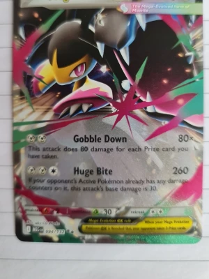 Pokémonkort Mega Mawile EX 094/132 - ( original ) Säljer ett samlarkort från Pokémon, Mega Mawile EX 094/132. Kortet har en färgstark design med svart, gult och rosa motiv och holografisk yta. Perfekt för dig som gillar att samla eller spela Pokémon TCG.