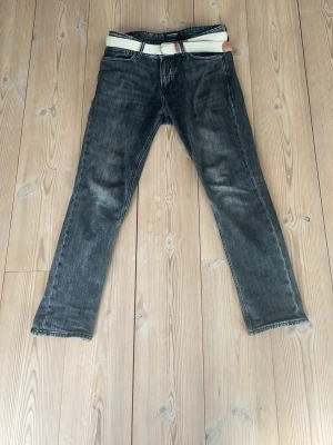 Jack & Jones jeans med beige flätat bälte som ingår. - Modell: regular/clark storlek: 29/30. 