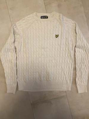 Kabelstickad Lyle & Scott tröja - Hej! Säljer en populär och riktigt snygg kabelstickad tröja av märket Lyle & Scott. Den är i storlek S och har 2 mindre hål som tydligt syns på bilderna. Ett hål är vid kragen. Det andra är vid armhålan så det är inget man tänker på, det är till och med ihopsytt. Funkar utmärkt som ett budgetalternativ. Perfekt för svala sommarkvällar! Tveka inte att höra av dig vid frågor!