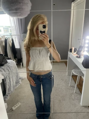 Blå bootcut jeans från Gina Tricot - Säljer ett par klassiska blå bootcut jeans från Gina Tricot. Jeansen har normal midja, utsvängda ben och snygga kontrastsömmar. Tillverkade i mjukt denimtyg som sitter bekvämt och ger en tidlös look. Perfekta till alla dina outfits!