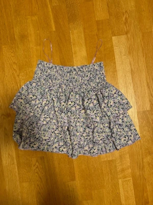 Blommig volang kjol  - Skit söt blommig volang kjol från Gina Tricot 💞 Knappt använd och i väldigt fint skick 🙌 Kan ju användas både som kjol och topp. Priset kan diskuteras vid snabb försäljning 🙏 Skriv för fler bilder på 💕