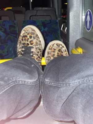Leopardmönstrade låga sneakers - Säljer ett par sneakers med leopardmönster och svarta skosnören. Skorna har vit sula och är i tygmaterial. Perfekta för dig som vill sticka ut med en djurisk vibe i din outfit.