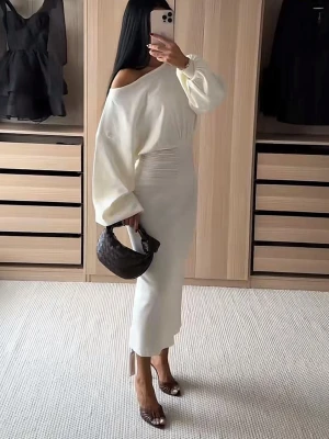 Vit offshoulder långklänning - Stilren vit långklänning med offshoulder-design och långa, puffiga ärmar. Klänningen har markerad midja och en elegant, figurnära passform. Perfekt för dig som gillar minimalistisk och trendig stil. Aldrig använd pågrund av fel storlek så prislappen är på.