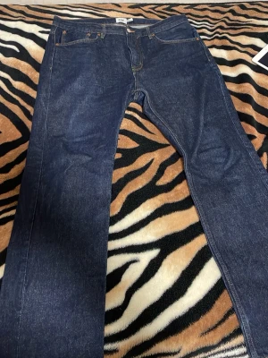 Mörkblå raka jeans från 157 - Säljer ett par mörkblå jeans från 157 med klassisk femficksdesign och raka ben. Jeansen har kontrastsömmar och metallknapp i midjan. Perfekta för dig som gillar en enkel och stilren look.