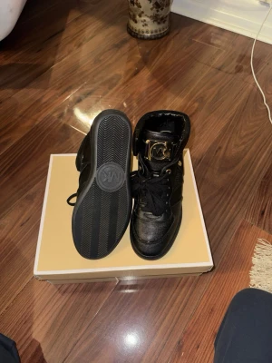 Svarta high top sneakers Michael Kors - Svarta high top sneakers från Michael Kors med guldfärgade detaljer, storlek 40-41, aldrig använda.