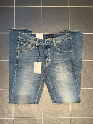 Blå slim fit jeans från Replay - Helt nya jeans ifrån tiger of Sweden med prislappen kvar på. Jeansen är i storlek w29 L32 och i modellen Sharp vilket är någon stans mellan slim och straight modellerna. Dom har även en riktigt snygg tvätt