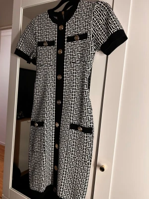 Midi klänning  - Stilren kortklänning med svartvitt mönster och  guldknappar framtill. Den är storlek S och köptes  utomlands för 600kr säljer den för 499 då den aldrig har använts. Prister går att diskutera❤️