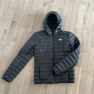 Dunjacka adidas - Säljer nu denna svarta dunjacka från Adidas | Skick 9/10 | Den har används fåtal gånger och har inga defekter | Storlek XS | Vid frågor är det bara att höra av sig!