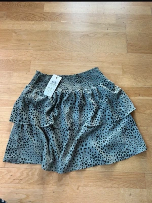 grön Volangkjol  - Säljer en superfin grön leopardmönstrad kjol från ONLY. Den har en smockad midja och volangdetaljer som ger en söt och fladdrig look. Helt ny med lapparna kvar 💚🐆✨