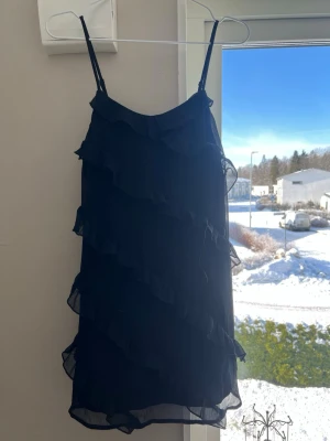 Svart volangklänning med tunna axelband💕 - Snygg kort svart klänning med tunna axelband och flera lager volanger i chiffongliknande material. Perfekt till sommaren eller andra tillfällen 