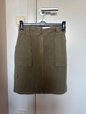 Olivgrön kjol med fickor - Snygg olivgrön kjol, perfekt för en avslappnad och trendig look.