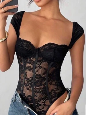 Svart spetskorsett med capärm - Trendig svart korsett i genomskinlig spets med blommönster och capärm. Urtagbara byglar och markerade sömmar ger en snygg siluett. Perfekt att styla med jeans för en cool look.