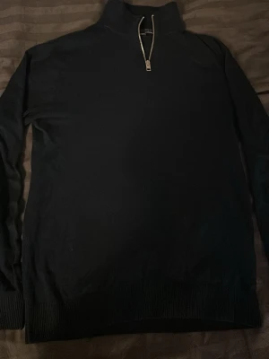 Svart halvzip tröja Jack & Jones - Snygg svart tröja från Jack & Jones med halvzip och hög krage. Tröjan har långa ärmar och ribbade muddar vid ärmslut och nederkant. Perfekt för lager på lager och enkel att matcha med olika outfits.