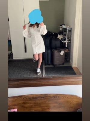 Vit klänning med puffärmar - Säljer en vit klänning med markerad midja och långa puffärmar. Klänningen har en kort, figurnära passform och dragkedja framtill. Perfekt för dig som gillar trendiga och feminina plagg. Endast använd 1 gång 