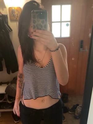 Randig Stickad Crop Top - Säljer en blåvit randig stickad top som har en extra detalj vid midjan på sidorna (se bild 3), aldrig använd 💕