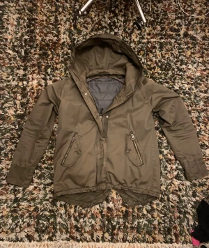 Mörkgrön Marc O Polo field jacka  - Riktigt fet Marc O Polo jacka med dragkedja och knappar framtill. Jackan har två snedställda fickor med dragkedja och två knappfickor bredvid. Insidan har ett quiltat, avtagbart foder som ger extra värme, vilket gör att jackan är perfekt för både höst, vinter och vår. Vid funderingar eller frågor om specifika bilder, fråga på! 