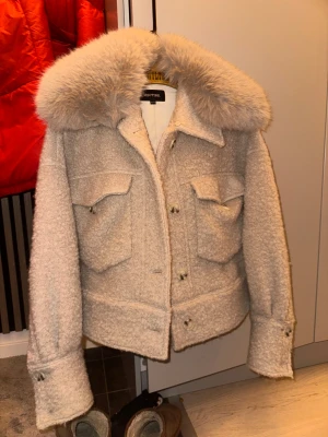 Beige pälsjacka från Meotine - Säljer en beige pälsjacka från Meotine med stor fluffig krage i fuskpäls och två stora bröstfickor med lock. Jackan säljs ej längre köpt för 4150kr 2024 knappt använd 