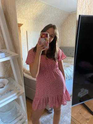Blommig klänning  - Blommig röd sommarklänning i tunnt och luftigt material. Storlek 38 men går mot en 36