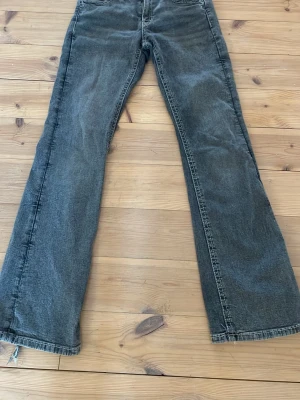 Gråa Gina tricot jeans - Gråa jeans från Gina tricot, mid waist/low waist, Har en enkel design på fickan. Har lite skav på fötterna men inget man tänker på, kan sys igen/ sys upp skulle jag tro. Pris kan alltid diskuteras!! 💞