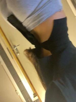 Svart croppad topp med öppen rygg - Trendig svart croppad topp med öppen rygg och breda band som knyts i ryggen. Toppen har en stilren look och passar perfekt till höga jeans eller kjol. Materialet känns mjukt och följsamt mot kroppen.