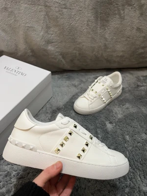 Valentino Rockstud/ Opens - vit/guldiga - Tjena! Säljer nu dessa valentino rockstuds. Helt nya, aldrig använda. Skicket är 10/10. De är vita med guldiga spikar. Storlek 38, passar 37/39. Så fråga gärna. Priset går att diskretas vid snabbaffär 