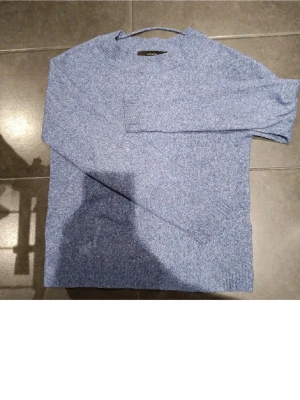 Stickad tröja vero Moda - Mysig blåmelerad stickad tröja från VERO MODA med rund halsringning och långa ärmar. Tröjan har ribbstickade muddar vid ärmslut och nederkant, perfekt för lager på lager. Enkel och stilren design som passar till det mesta.