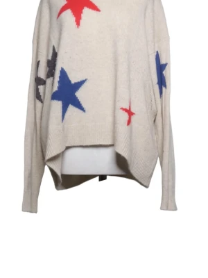 Beige stickad tröja med stjärnor - Säljer en oversized beige stickad tröja med stora stjärnor i blått, rött och svart. Tröjan har lång ärm och avslappnad passform med något längre bakstycke. Perfekt för dig som gillar en cool och avslappnad stil.