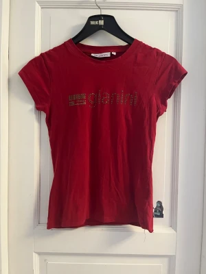 Röd topp med tryck GIANINI - Röd y2k topp med guldigt tryck. Använt en gång. Ganska åtsittande