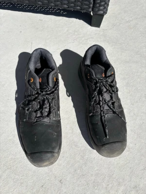 Svarta arbetsskor från Gesto - Svarta arbetsskor från Gesto med robust sula och snörning. Skorna har även stålhätta. De är använda sparsamt och i gott skick