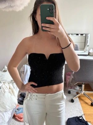 Svart bandeau tubtopp - Svart bandeau tubtopp med croppad passform och en snygg v-ringning! 