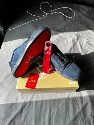 Mörkblåa Louboutin skor med kvitto - Nya mörkblåa Christian Louboutin skor i storlek 46 med kvitto. Skorna är gjorda i mocka och har mörkblå skosnören. Medföljer originalkartong, dustbag, kvitto, louboutin kort och skohorn i rött.