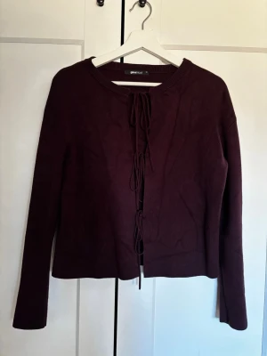 Vinröd kofta med knytning från Ginatricot - Jättefin och mysig vinröd kofta från Ginatricot med långa ärmar och snygg knytning framtill. Koftan har rund halsringning och är tillverkad i mjukt stickat material. Perfekt för lager på lager och en stilren look. Säljer då den inte kommer till användning, därav knappt använd och i princip nyskick. Pris kan diskuteras och bara att skriva för fler bilder eller annat!💗