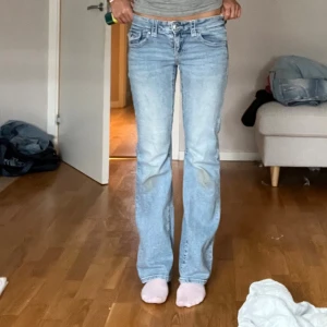 Ljusblå bootcut jeans låg midja - Säljer ett par ljusblå jeans med bootcut och låg midja. Jeansen är från Gina och har den klassiska fick designen med knappar där bak. Supersnygga!! Kolla min sida för mer plagg