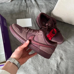 Nike SB Dunk Low burgundy sneakers - Säljer ett par Nike SB Dunk Low sneakers i burgundy och mörkröd mocka. Modell City of Love. Cool sko, riktigt bekväm med. 