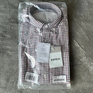 Rutig skjorta från Aspesi - Säljer en snygg rutig skjorta från Aspesi. Helt ny i förpackningen, storleken är s men sitter S/M. Storleken funkar bra på mig som är 180.